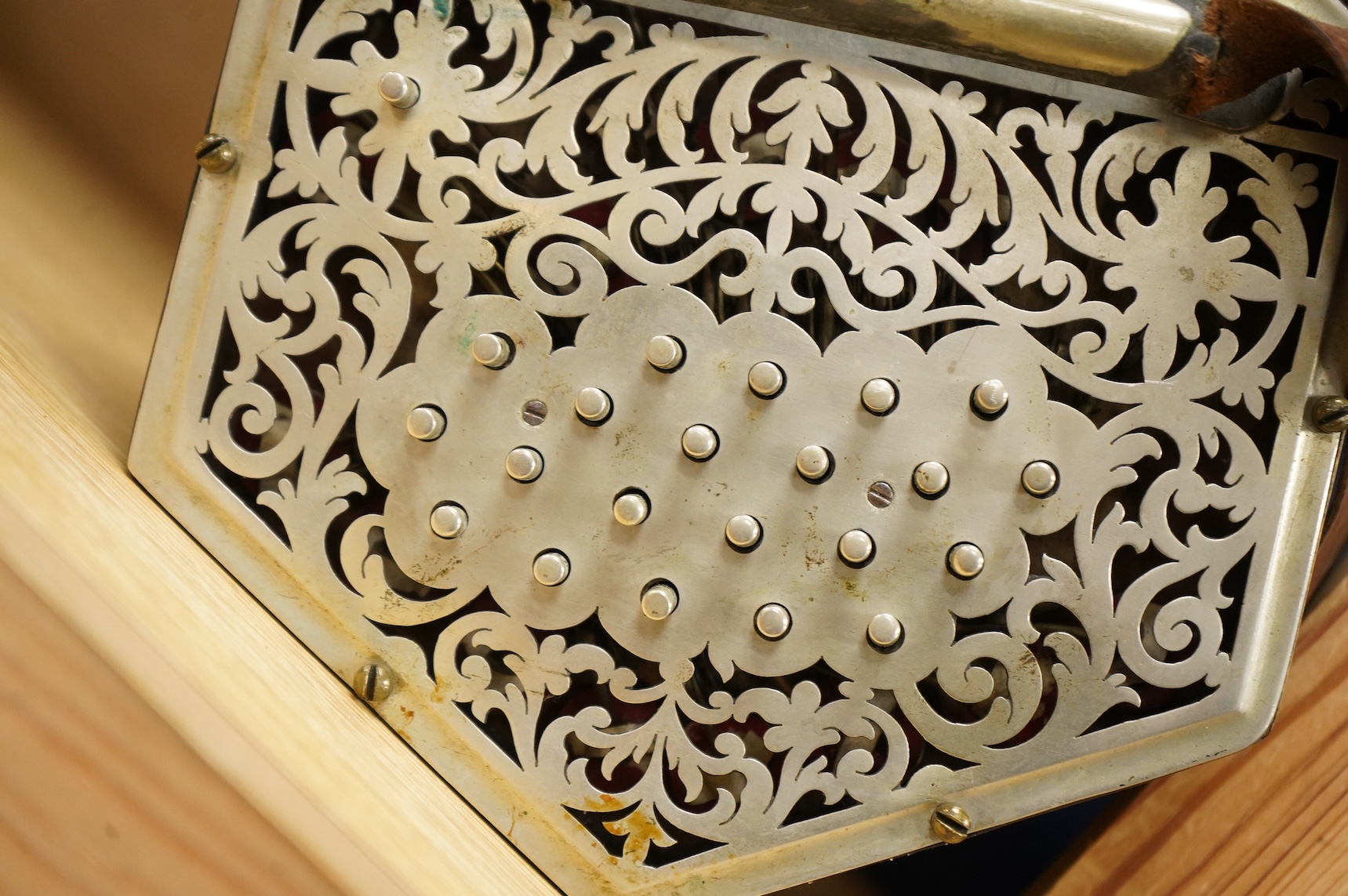 A Jeffries hexagonal concertina with pierced silvered metal ends, and gilt tooled leather bellows, maker’s mark stamped to the metal work on one end